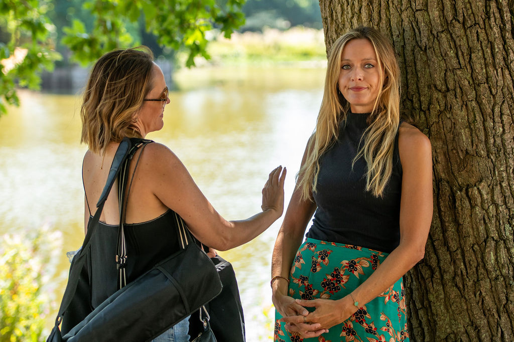 Our founder, Claire, talking with a client by a tree in the park