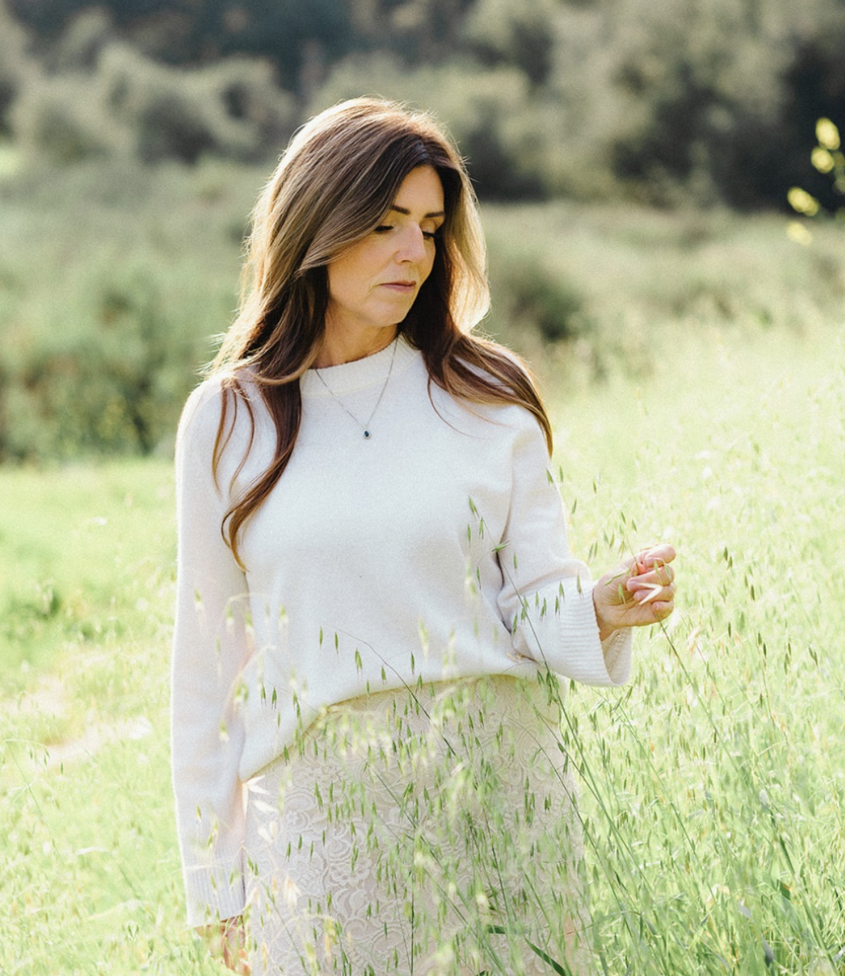 Dr MJ standing in a sunlit field